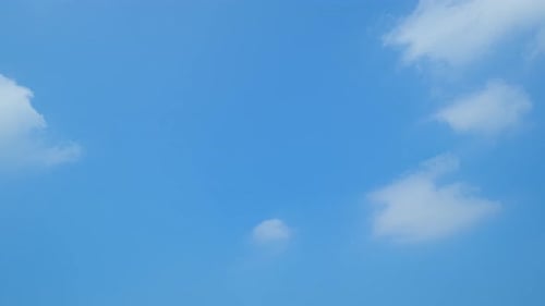 Flauschige Wolken, die sich im Zeitraffer am blauen Himmel bewegen