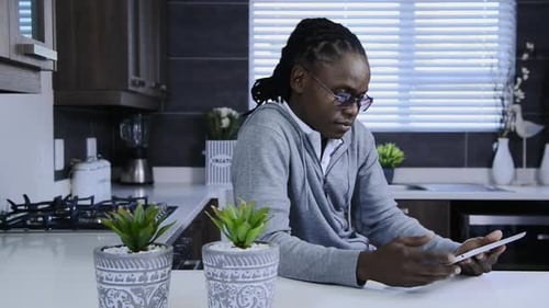 Man in Kitchen Smiling Using a Tablet
