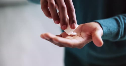 Close Up of Person Pouring Pills into Hand