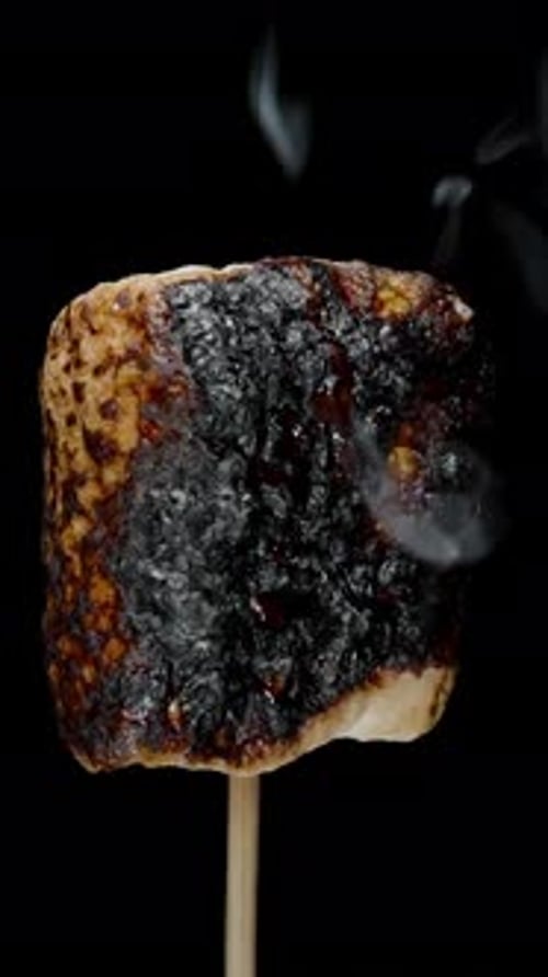 Vertical video. Sugar Marshmallow on Stick Charring and Emitting Smoke Rings. Sugar Bubbling on