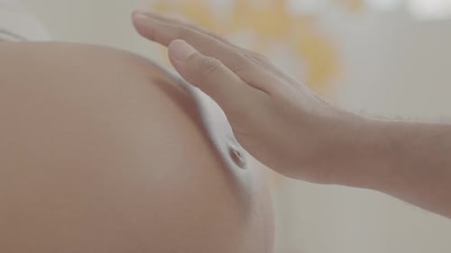 Papá siente una patada de bebé en el vientre de la madre