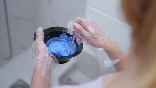 Woman Mixing Hair Dye in Bowl with Gloves