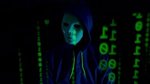 Anonymer Hacker mit Maske und Hoodie, der in einem dunklen Raum mit digitalen Daten interagiert