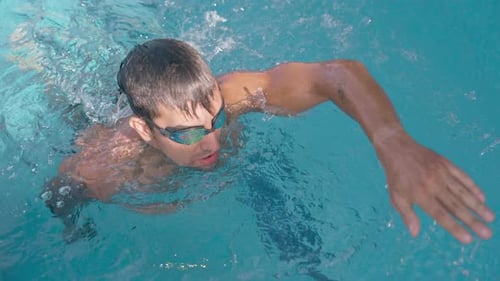 Hombre nadando en estilo libre en la piscina durante una sesión de entrenamiento al aire libre
