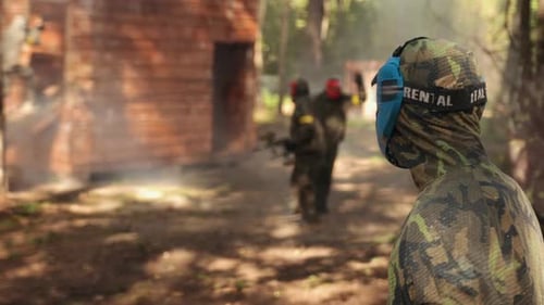 Participating in a Leisure Activity Playing Paintball with Friends Wearing Camouflage Masks