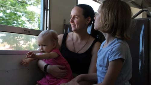 Madre con sus hijos mirando por la ventana del tren