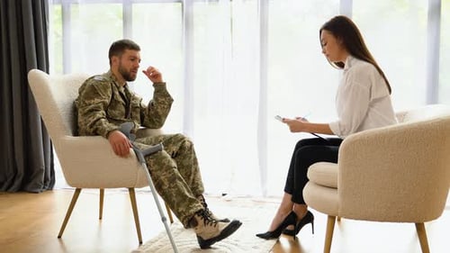 Man in Military Garb Talking With Woman in Office