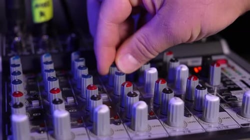Close-up of sound mixer console in recording studio. Male hands