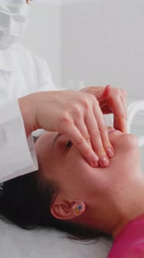 Cosmetology Therapist Making Woman Relaxing Spa Face Massage with Hands at Salon Detox and Healing