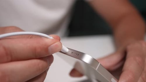 Close Up Silver Smartphone Plugging In Cable