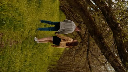 A young couple holding hands run through the forest, embodying an active lifestyle and tourism. Spor