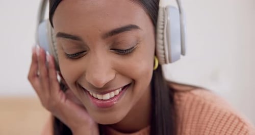 Woman Smiles and Listens to Music on Headphones