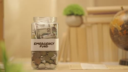Emergency Fund Jar Filled with Dollars and Coins