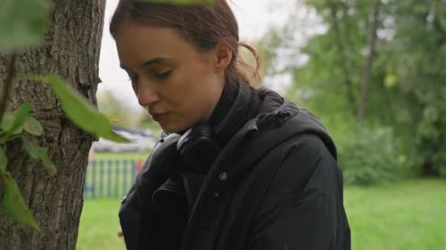 Contemplative Girl Near Trees Woman with Headphones in Peaceful Park Setting Female with Headphones
