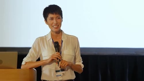 Young Asian businesswoman speaking in speaker on stage in auditorium 4k