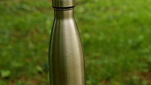 Water Bottle Reusable Steel Thermo Water Bottle on Green Grass Sustainable Lifestyle Plastic Free