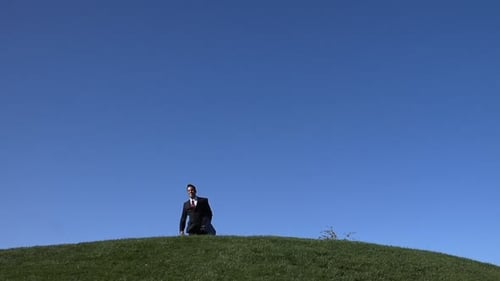 Businessman Jumps With Joy On Hilltop