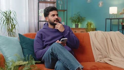 Man Using Mobile Phone While Relaxing on Sofa