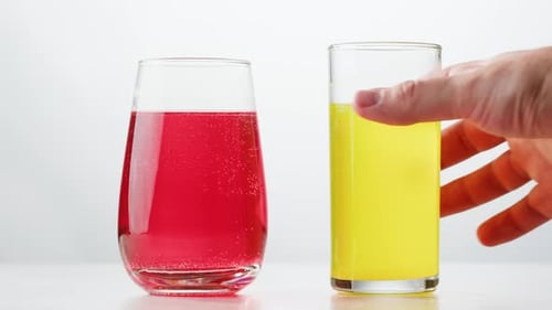 Hand Picks Up Glass of Yellow Soda