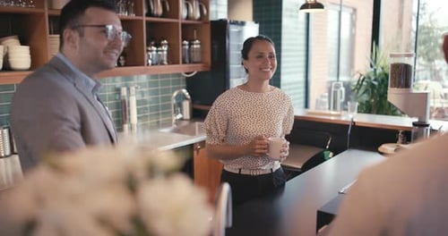 Smiling businesswoman discussing startup success with coworkers in modern office