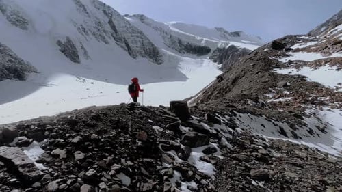 Lone Hiker Trekking in Snowy Mountain Landscape