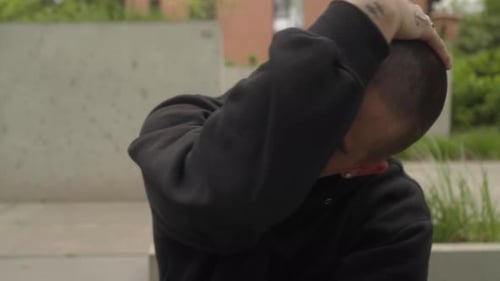 Man in Hoodie Rubs Face, Tattoos, City