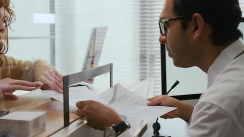 Bank Employee Interacting with Documents of Woman