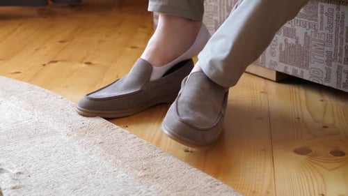 Man Putting on Casual Shoes with Shoehorn Indoors