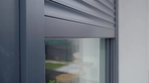 Window Shutter Closing on House Exterior in Daytime