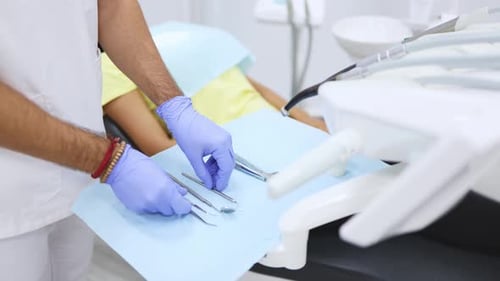 Male dentist arranging dental tools in modern clinic