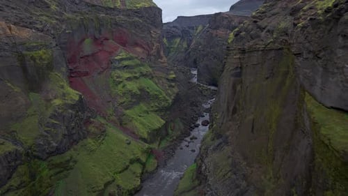 Majestic drone shot soaring between towering mountain ridges and a hidden valley.