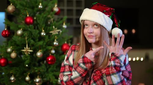 Young Woman in Santa Hat Points to Fingers