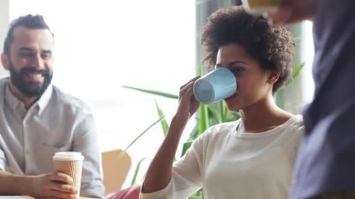Group of colleagues socializing in bright modern office