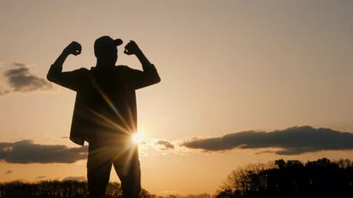 Silhouette Of Person Celebrating Success at Sunset