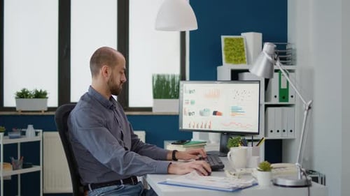 Business Man Doing Financial Research on Computer in Startup Office