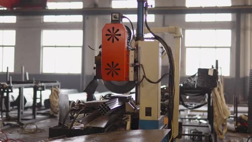 Industrial Cutting Machines are Working Within Modern Factory Environment Processing Metal Profiles