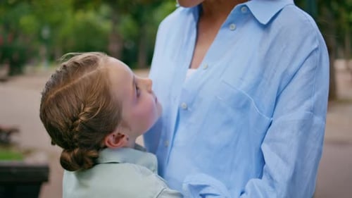 Portrait Cute Child Embracing Mom in Park Resting Together Woman Looking Camera