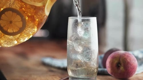 Refreshing Iced Tea Pouring into a Glass with Ice