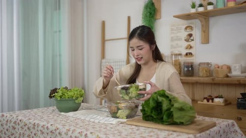 Woman Preparing Fresh Salad in a Sunny Kitchen