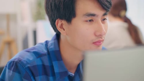 Exhausted Asain business man using laptop computer working in office.