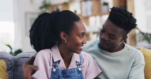 Smiling Couple Embraces on Couch Together