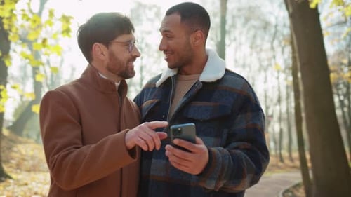 Affectionate Couple Looking at Smartphone in Autumn Park