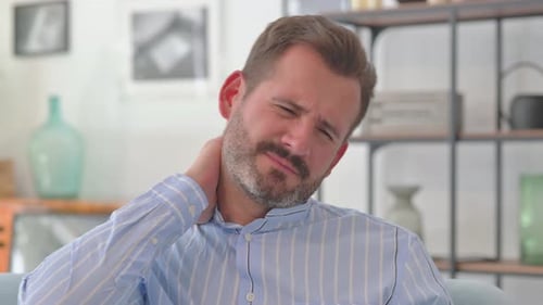 Man Massaging Neck Due To Painful Injury