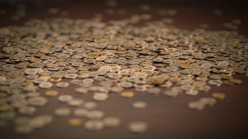 Pile of Small Coins on a Wooden Surface