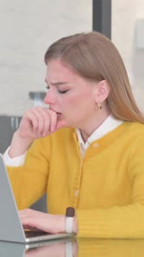 Coughing Blonde Casual Woman Using Laptop in Office, vertical video