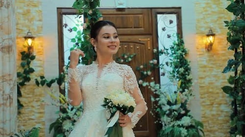 Beautiful Woman in Wedding Dress Holds Bouquet