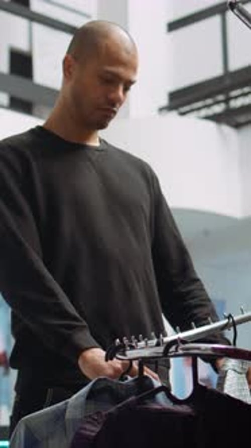 Vertical Video Middle Eastern Customer Explores the Latest Fashion Collection at a Mall Store