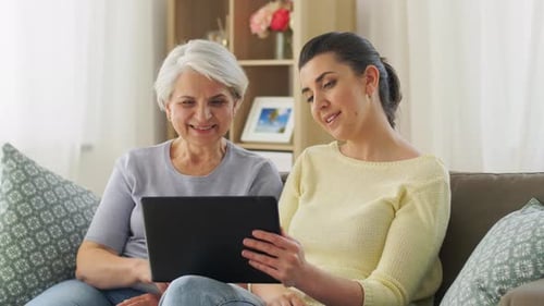 Woman Video Chatting with Senior Family Member on Tablet