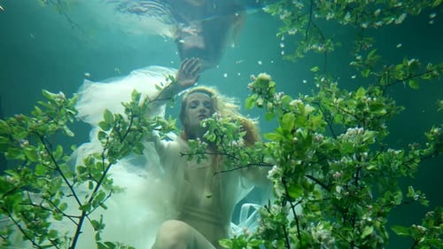 Romantische Brautfrau im weißen Kleid, die unter Wasser im fabelhaften See schwimmt Mysteriöse Dame in der Tiefe