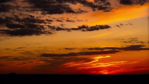 Zeitraffer eines Dramatisch orange-roten Sonnenuntergangs mit dunklen Wolken